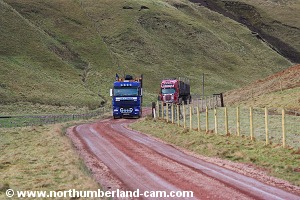Timber trucks approaching from behind.